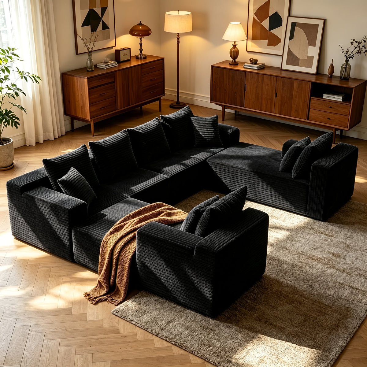 Black U-shaped cloud sofa with throw blanket