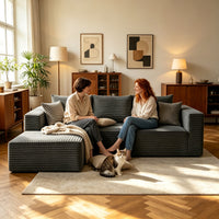 Two people relaxing on the dark gray L-shaped cloud sofa